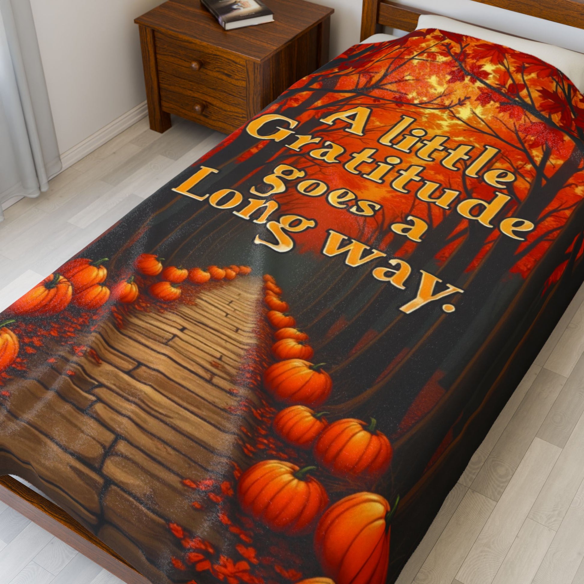 Soft fall blanket with quote “A Little Gratitude Goes a Long Way,” cozy autumn mindfulness design in warm tones.