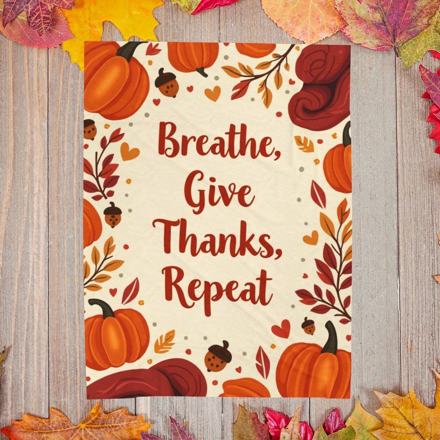 Cozy blanket with “Breathe, Give Thanks, Repeat,” autumn mindfulness theme in orange and gold hues.