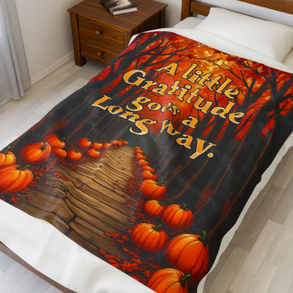 Soft fall blanket with quote “A Little Gratitude Goes a Long Way,” cozy autumn mindfulness design in warm tones.