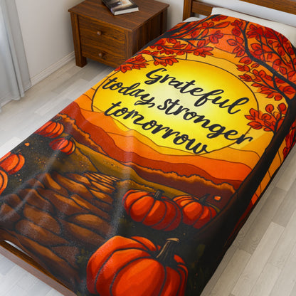 Motivational blanket with “Grateful Today, Stronger Tomorrow,” positive fall mindfulness message.