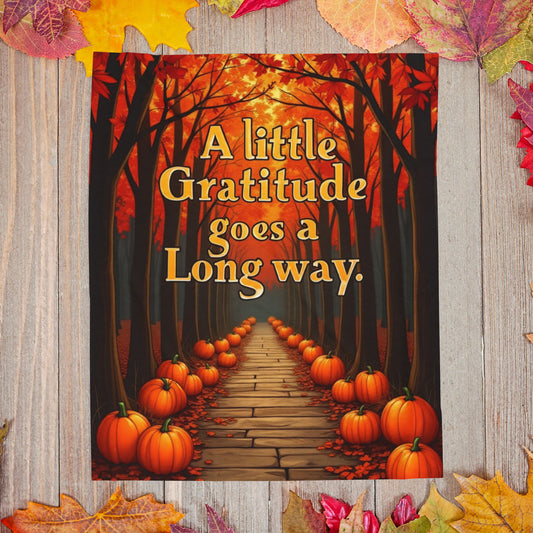 Soft fall blanket with quote “A Little Gratitude Goes a Long Way,” cozy autumn mindfulness design in warm tones.