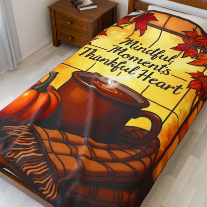 Cozy blanket with “Mindful Moments, Thankful Heart,” autumn mindfulness theme in warm orange and red.