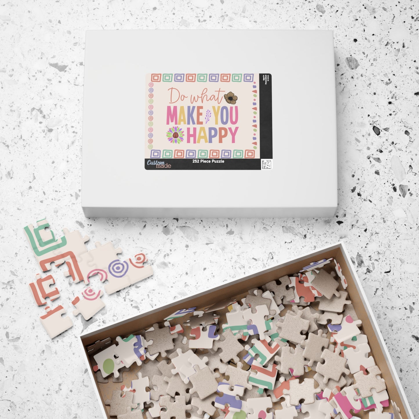 Jigsaw puzzle set with pieces and packaging on a textured surface