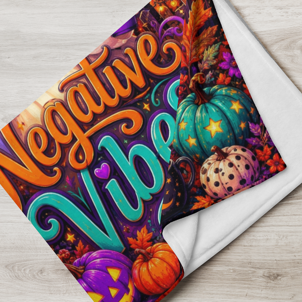 A rectangular Halloween-themed blanket displayed against a light wood plank background. The artwork features the words 'Ghosting Negative Vibes' in large decorative lettering, with a cartoon ghost wearing a witch hat and sunglasses, surrounded by pumpkins, a moonlit sky, a house, and lanterns.