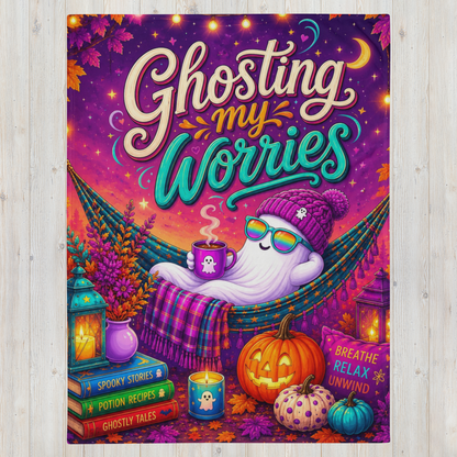 A colorful Halloween-themed art blanket with the phrase “Ghosting my Worries” in large decorative lettering. The scene shows a white ghost lounging in a hammock, surrounded by pumpkins, candles, books, and autumn leaves, with a purple and orange sky background.