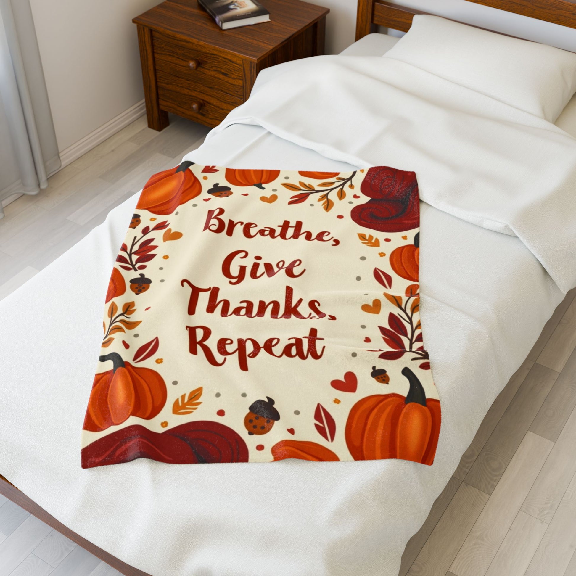 Cozy blanket with “Breathe, Give Thanks, Repeat,” autumn mindfulness theme in orange and gold hues.