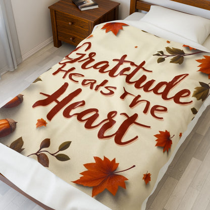 Cozy blanket reading “Gratitude Heals the Heart,” autumn mindfulness design promoting warmth and peace.