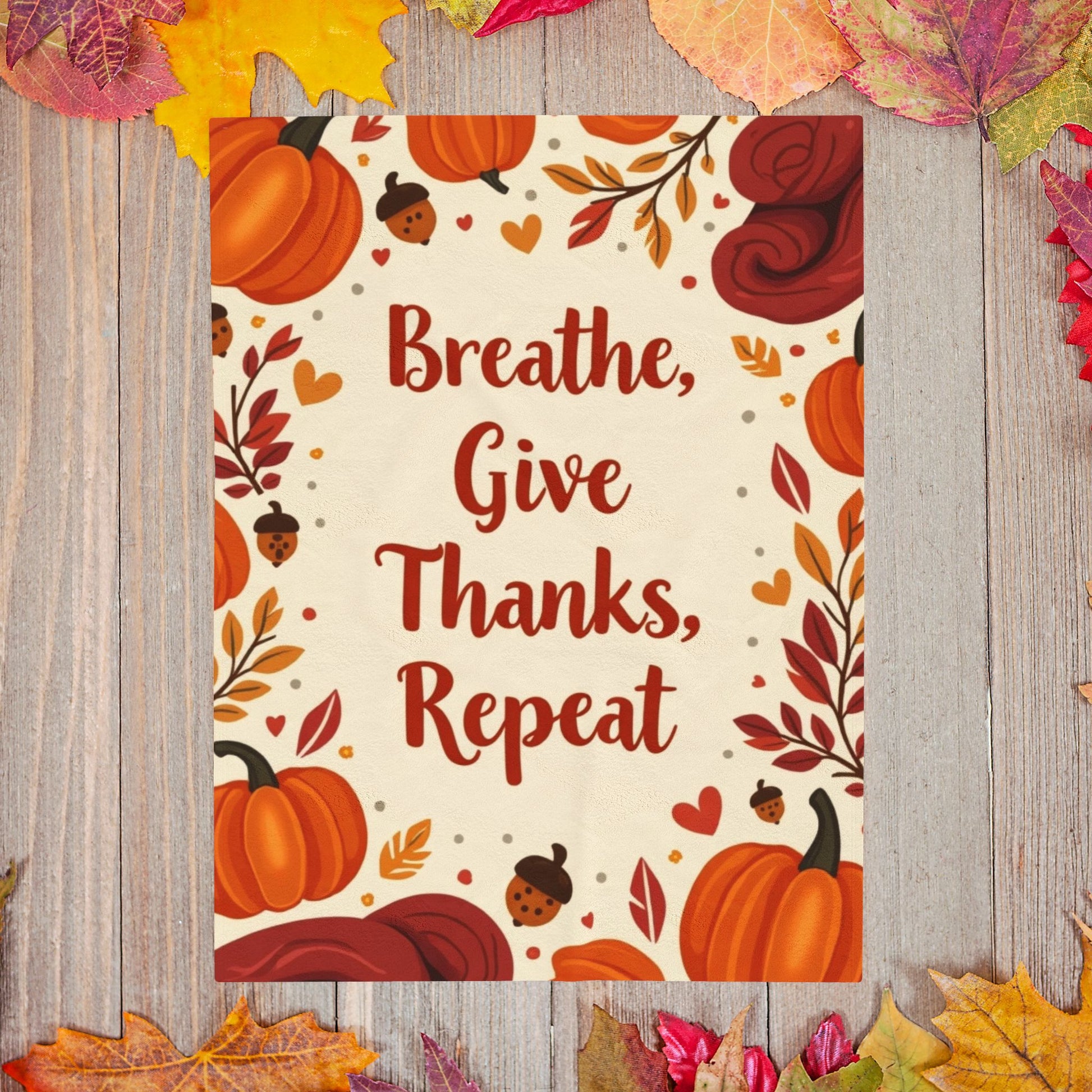 Cozy blanket with “Breathe, Give Thanks, Repeat,” autumn mindfulness theme in orange and gold hues.