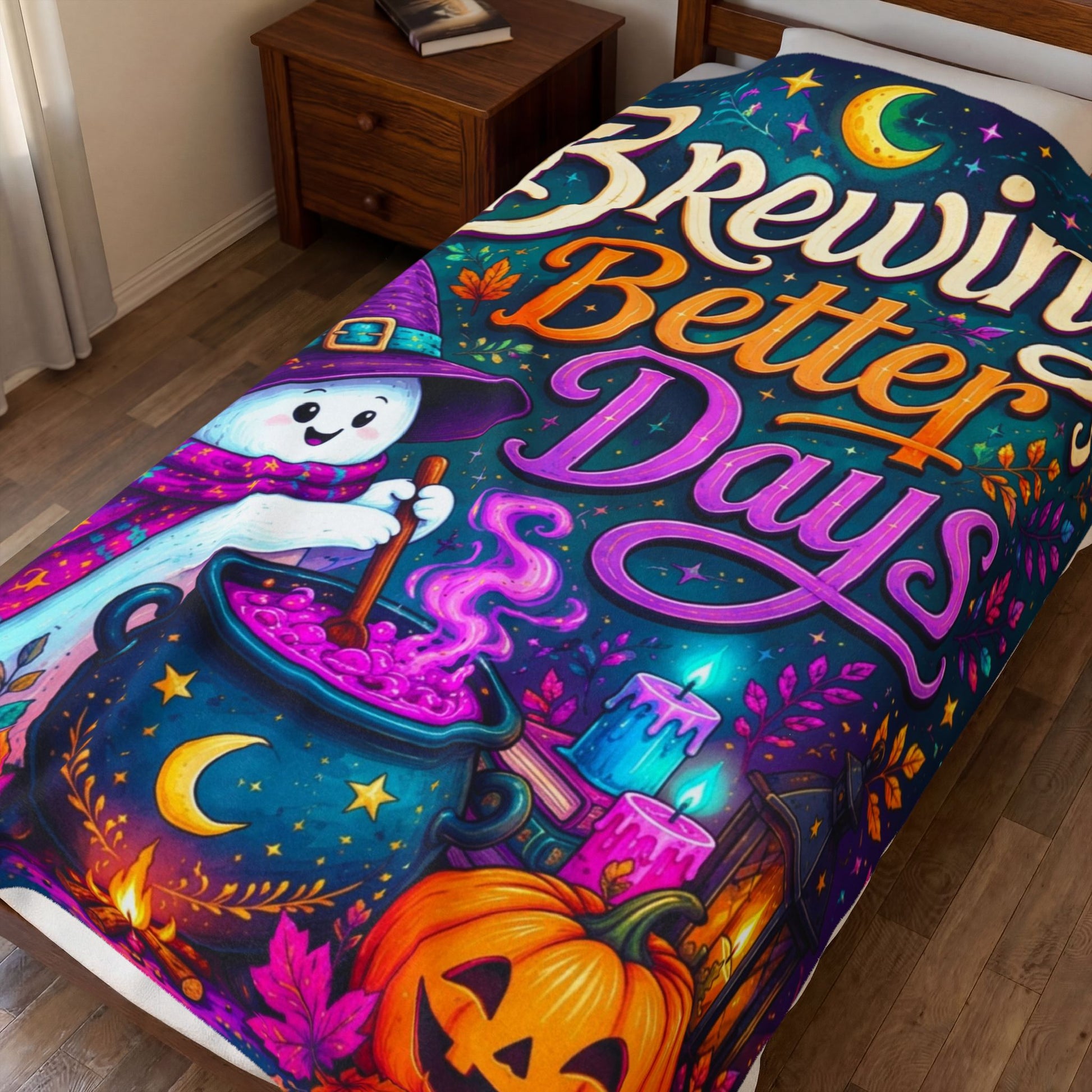 A colorful Halloween-themed blanket, displayed on a bed in a bedroom setting. The design features a whimsical cartoon witch stirring a glowing cauldron with the text 'Brewing Better Days' in stylized fonts, alongside a jack-o'-lantern, candles, and a crescent moon.
