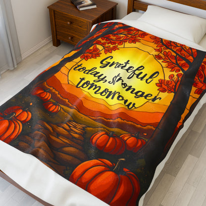 Motivational blanket with “Grateful Today, Stronger Tomorrow,” positive fall mindfulness message.