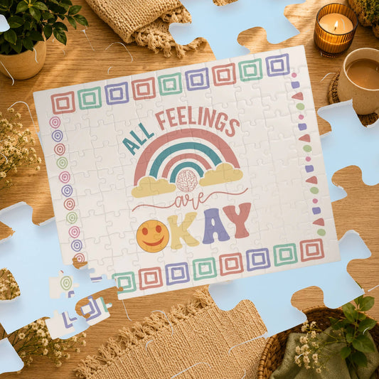 Puzzle with 'All Feelings Are Okay' message on a wooden table with decorative items.
