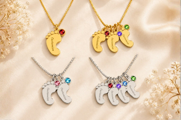 Footprint-shaped necklaces with engraved names and colored stones on a soft beige background.