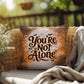 Indoor/outdoor mental health pillow with “You’re Not Alone” to promote comfort and support