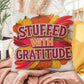 Stuffed With Gratitude throw pillow featuring Thanksgiving quote and warm fall seasonal décor accent
